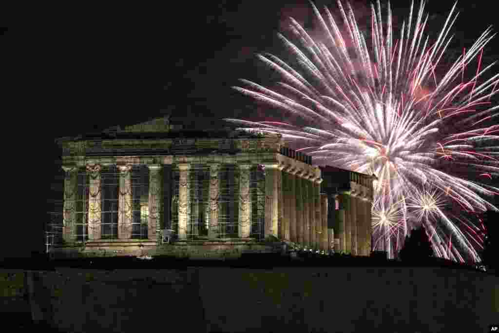 Fireworks explode over the ancient Parthenon temple at the Acropolis hill during New Year's celebrations in Athens, Greece, Jan. 1, 2024.