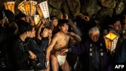 Men prepare to cleanse their bodies in a river during the Sominsai Festival at Kokuseki-ji Temple in Oshu, Iwate Prefecture, Japan, Feb. 17, 2024.