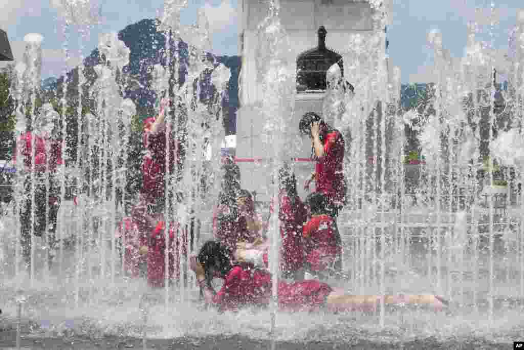 Gangsol elementary school students cool themselves off in a public fountain in Seoul, South Korea.