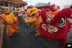 Cambodian Chinese community members perform lion dance on Friday, Feb. 9, 2024, in front of Royal Palace in Phnom Penh, Cambodia, ahead of Lunar New Year. (AP Photo/Heng Sinith)