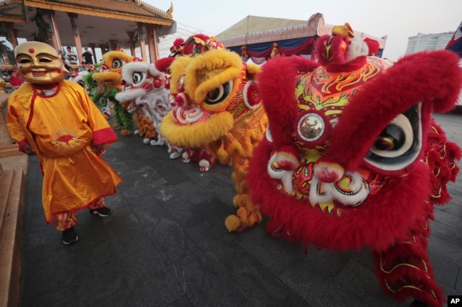 Cambodian Chinese community members perform lion dance on Friday, Feb. 9, 2024, in front of Royal Palace in Phnom Penh, Cambodia, ahead of Lunar New Year. (AP Photo/Heng Sinith)