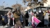 FILE — A member of Taliban forces fires in the air to disperse the Afghan women during a rally to protest against what the protesters say is Taliban restrictions on women, in Kabul, Dec. 28, 2021. 