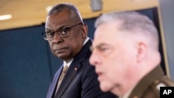 Secretary of Defense Lloyd Austin, left, listens to Chairman of the Joint Chiefs Gen. Mark Milley speak during a briefing at the Pentagon in Washington, March 15, 2023.