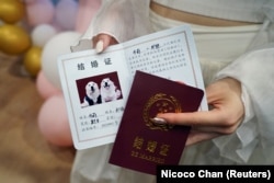 Gigi Chen shows pretend wedding certificates for newly married dogs Bree and Bond, in Shanghai, China June 29, 2024. (REUTERS/Nicoco Chan)