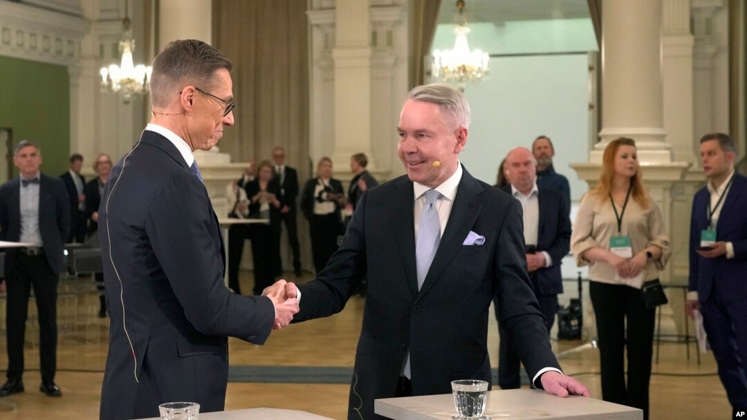 National Coalition Party candidate Alexander Stubb, left, and Social Movement candidate Pekka Haavisto shake hands during a presidential election event, at Helsinki City Hall, in Helsinki, Finland, Feb. 11, 2024. 