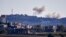 FILE - A picture taken from from the southern Lebanese village of Tayr Harfa, near the border with Israel, shows smoke from rockets fired by Hezbollah billowing near an Israeli outpost on Dec. 15, 2023. 