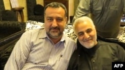 This undated handout photo shows Razi Moussavi, left, sitting alongside the commander of the IRGC's Quds Force, Qasem Soleimani, who was killed by a U.S. drone strike in Iraq in 2020. Moussavi was killed in an Israeli strike in Syria on Dec. 25, 2023. (Tasnim News via AFP)