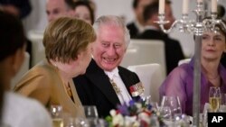 Raja Inggris Charles III berbicara dengan mantan Kanselir Jerman Angela Merkel dalam acara jamuan makan malam di Bellevue Palace, Berlin, pada 29 Maret 2023. (Foto: Bernd von Jutrczenka/Pool via AP)