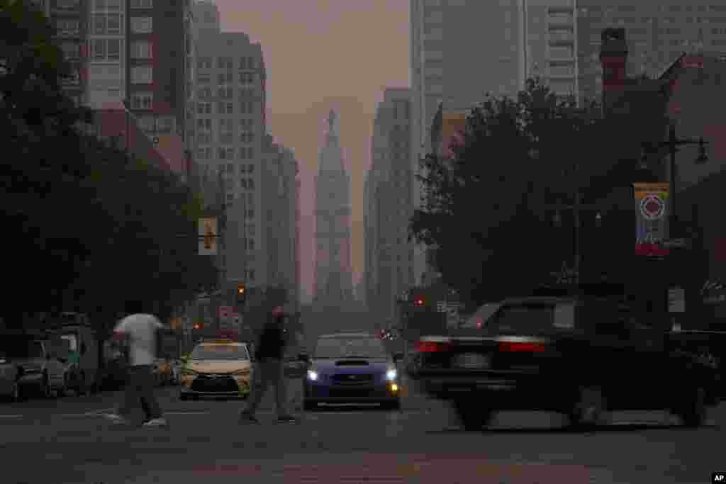 Evening commuters travel on Broad Street past a hazy City Hall, June 7, 2023, in Philadelphia, Pennsylvania. &nbsp;Smoke from Canadian wildfires poured into the U.S. East Coast and Midwest on Wednesday, covering the capitals of both nations in an unhealthy haze, and prompting people to fish out pandemic-era face masks.