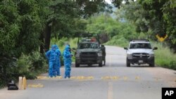 ARCHIVO - Investigadores de la policía mexicana trabajan en la escena de los policías asesinados en El Papayo, municipio de Coyuca de Benítez, estado de Guerrero, México, el lunes 23 de octubre de 2023.