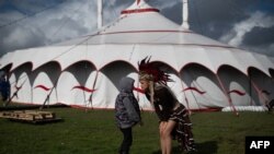 Ukrainian performer Julia Gorodetska speaks with her son Valdis, age 7, outside Circus Cortex's big top tent during a break in a dress rehearsal of their show "Warriors" in Sheffield, England, on March 30, 2023. 