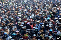 Para mengendara sepeda motor berdesakan untuk naik kapal feri yang akan membewa mereka menyeberang ke Pulau Sumatera menjelang Hari Raya Idulfitri di Pelabuhan Ciwandan, Cilegon, 7 April 2024. (AP/Dziki Oktomauliadi)