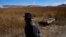 An Aymara man walks past an abandoned boat near the shore of Lake Titicaca in Huarina, Bolivia, on July 27, 2023. The lake's low water level is affecting local communities that rely on the natural border between Peru and Bolivia for their livelihood.