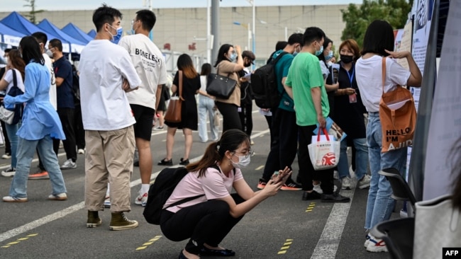 FILE - A woman uses her phone during a job fair in Beijing on Aug. 26, 2022. The unemployment rate among 16- to 24-year-olds in China reached a record high of 21.3% in June 2023, according to official data.