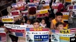 Afghan refugees hold placards during a gathering in Islamabad, Pakistan, July 21, 2023.