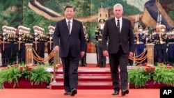 In this photo released by China's Xinhua News Agency, Chinese President Xi Jinping, left, and Cuba's President Miguel Diaz-Canel Bermudez walk during a welcome ceremony at the Great Hall of the People in Beijing, Nov. 25, 2022.