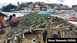 FILE - Rohingya refugees build a bamboo-and-tarpaulin shack in Balukhali camp, Cox's Bazar district, Bangladesh. Over 1 million Rohingya refugees live in camps in Bangladesh.
