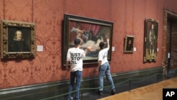 Activists hit the protective glass on a painting at the National Gallery in London, Nov. 6, 2023, in this photo provided by Just Stop Oil.