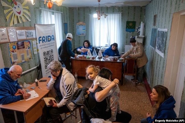 FILE - Medical volunteers of FRIDA Ukraine examine patients while providing medical care for civilians in Donetsk area, Ukraine on March 19, 2023. (AP Photo/Evgeniy Maloletka)