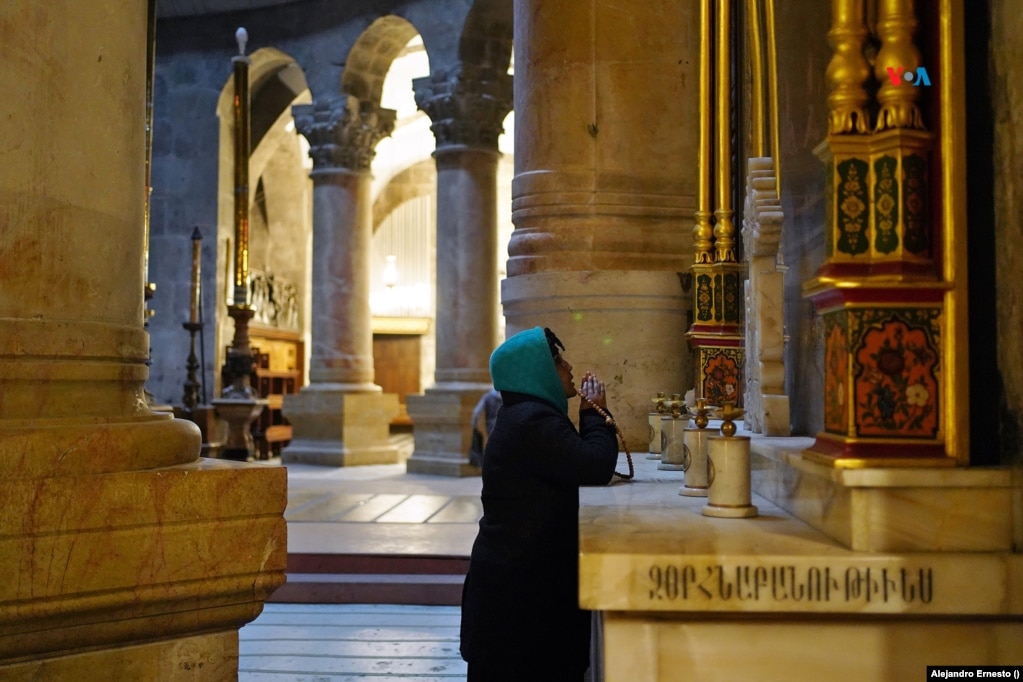 Una mujer ora ante uno de los altares del Santo Sepulcro de Jerusalén.