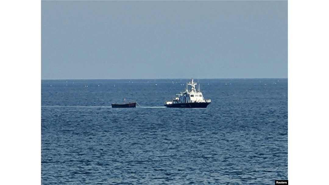 Sebuah kapal militer Korea Selatan menarik kapal Korea Utara yang membawa orang-orang yang diyakini berusaha membelot dari negara tersebut, ke pelabuhan di Yangyang, Korea Selatan, 24 Oktober 2023. (Foto: Yonhap via REUTERS)