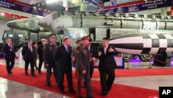 In this photo provided by the North Korean government, North Korean leader Kim Jong Un, right, with a Russian delegation led by its Defense Minister Sergei Shoigu visits an arms exhibition in Pyongyang, North Korea, July 26, 2023.