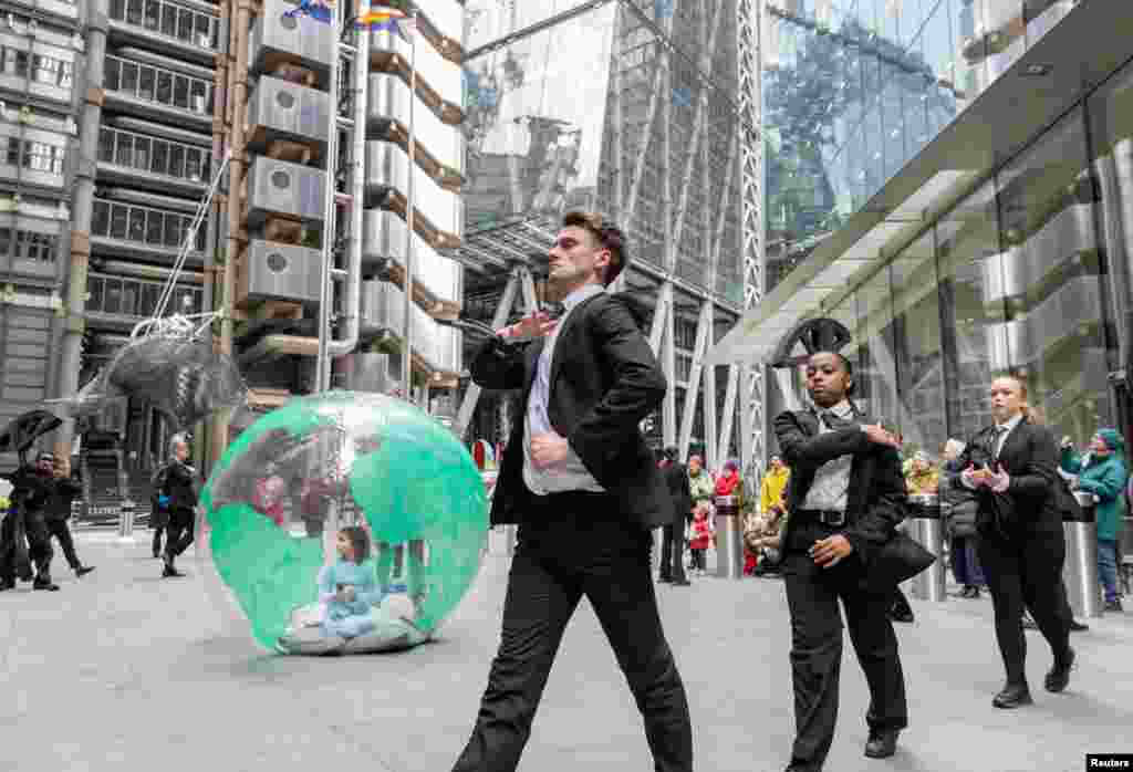 Activists from Mothers Rise Up, a campaign for climate action, dance outside Lloyd&#39;s of London.
