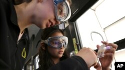 Students Siari Rodriguez, left, and Crystal Baker use a pH strip to test the pH of common substances in their Chemistry 121 class at Everett Community College, March 10, 2023. 