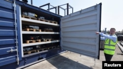 Marc Trent, CEO of vehicle dismantler company Charles Trent Ltd, opens up a specially-built, fire-safe container for batteries salvaged from written-off electric vehicles and hybrids in Poole, Britain, June 7, 2023.