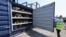 Marc Trent, CEO of vehicle dismantler company Charles Trent Ltd, opens up a specially-built, fire-safe container for batteries salvaged from written-off electric vehicles and hybrids in Poole, Britain, June 7, 2023.