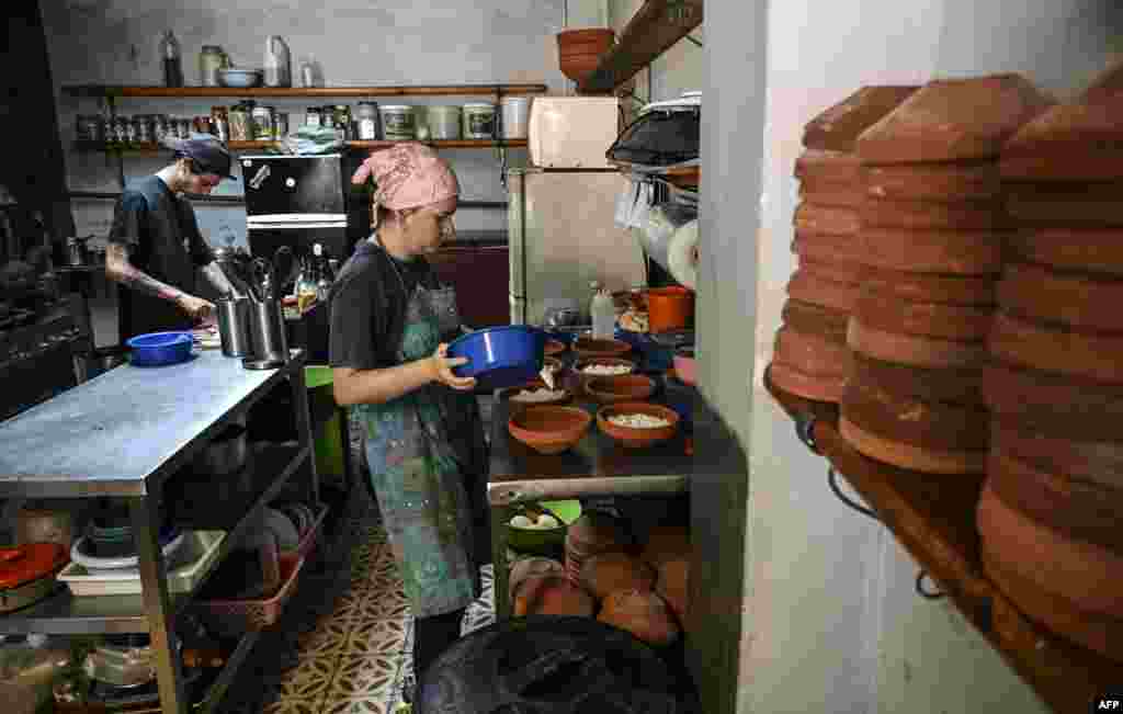 Una mujer y un hombre preparan raciones de comida en su negocio particular &quot;Rico desde casa&quot; en La Habana, Cuba. Este emprendimiento es una de las Mipymes que fueran aprobadas en 2021 por el gobierno cubano para intentar acelerar la economía local.