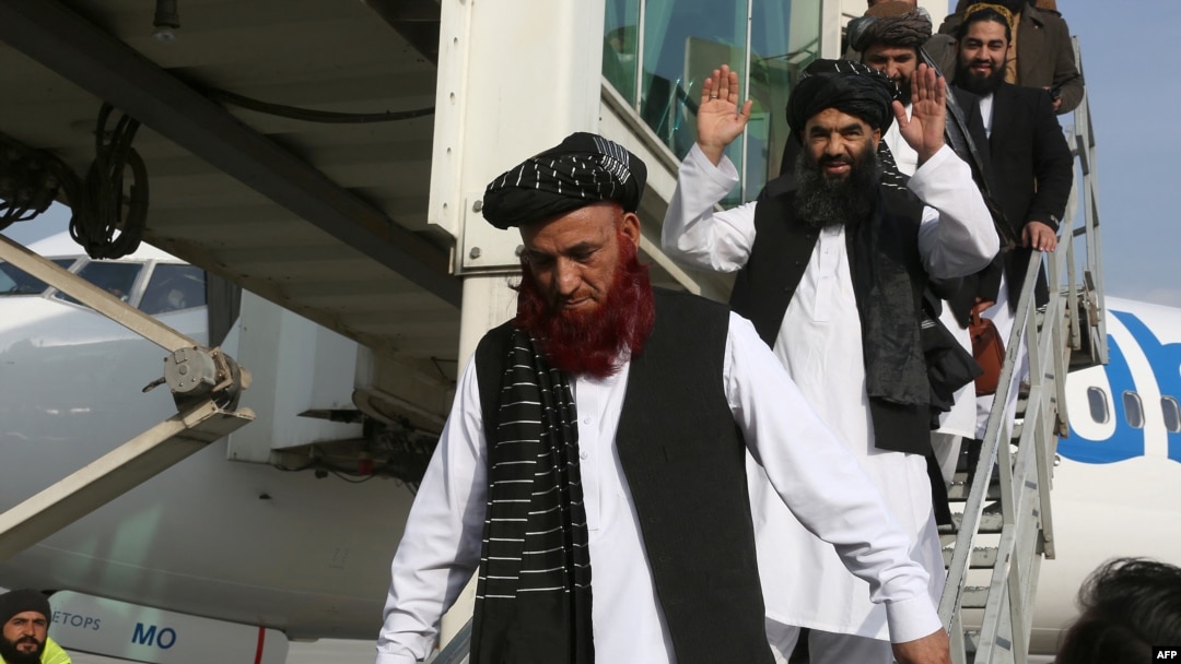Abdul Karim (kiri) dan Abdul Zahir (tengah), dua mantan tahanan yang ditahan di pusat penahanan AS di Teluk Guantanamo, tiba di bandara Kabul di Kabul, Afghanistan, 12 Februari 2024.