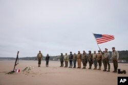 World War II reenactors pay homage to U.S soldiers on Omaha Beach in Saint-Laurent-sur-Mer, Normandy, June 6, 2023. The D-Day invasion that helped change the course of World War II was unprecedented in scale and audacity.
