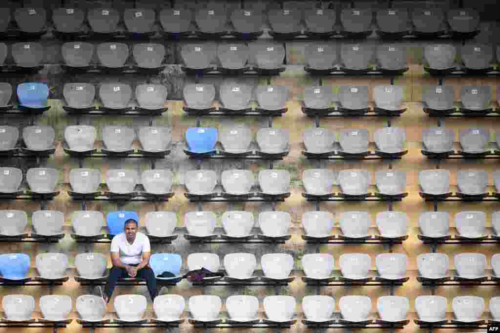 A spectator watches from the stands the first day of the second Test cricket match between India and England at the Y.S. Rajasekhara Reddy cricket stadium in Visakhapatnam.