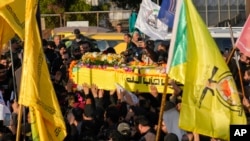 Fighters of the Popular Mobilization Forces carry the coffin of Wisam Mohammad al-Saedi, a commander of the Kataib Hezbollah paramilitary group, who was killed in a U.S. drone strike, in Baghdad, Iraq, Feb. 8, 2024.