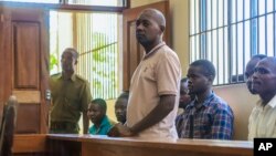 Paul Makenzi, who was arrested on suspicion of telling his followers to fast to death in order to meet Jesus, accompanied by some of his followers, appears at a court in Malindi, Kenya, on April 17, 2023.
