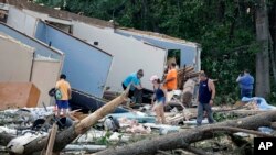 People survey the damage to their home that was destroyed by a tornado on July 19, 2023, in Dortches, N.C.