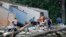 People survey the damage to their home that was destroyed by a tornado on July 19, 2023, in Dortches, N.C.