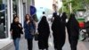 FILE - Iranian women make their way along a sidewalk in downtown Tehran, Apr. 26, 2016. 