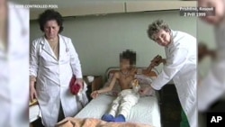 Një vajzë shqiptare mbahet nga infermieret në Klinikën Kirurgjikale të Prishtinës që të filmohet nga kamerat në një rast të organizuar veçanërisht për mediat ndërkombëtare nga Drejtoria serbe e QKUK-së më 2 Prill 1999
