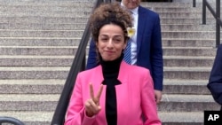 Masih Alinejad, una abierta opositora al régimen de Irán y radicada en EEUU, hace el signo de victoria al salir de la corte federal de Manhattan, el 7 de abril de 2023, en Nueva York, después de la sentencia a una californiana por participar en un intento de secuestrarla.