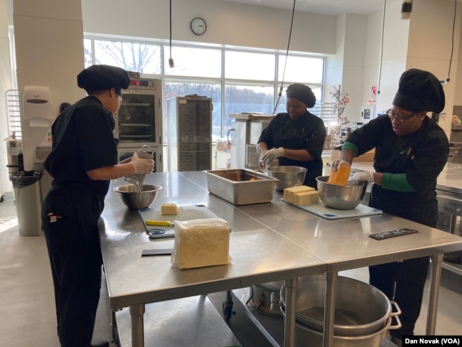 Participants at the Delaware Food Bank culinary school in Newark, DE, prepare cheese as a part of class, on February 4, 2024. (Dan Novak/VOA)