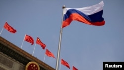 FILE - The Russian flag flies in front of the Great Hall of the People before a welcoming ceremony for Russian Prime Minister Mikhail Mishustin in Beijing, China, May 24, 2023. 