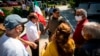 FILE - Demonstrators speak with a member of the Fulton County Sheriff's Office in front of a polling place for Iranian Americans taking part in Iran's presidential elections on June 18, 2021, in Sandy Springs, Georgia.
