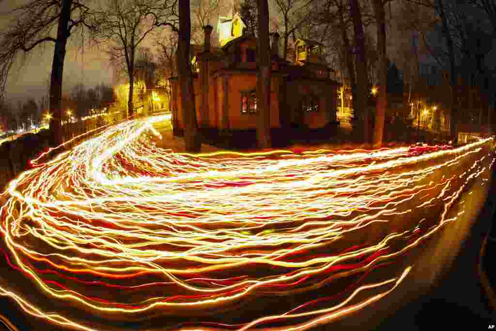 In this time exposure photo, Orthodox worshipers trail candle lights around a church during Orthodox Easter midnight mass in St. Petersburg, Russia, April 16, 2023. 