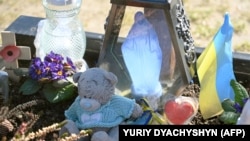 This photograph taken March 18, 2023, shows toys, flowers, and a miniature Ukrainian flag left by relatives and friends at a grave at the military section of Lychakiv cemetery in Lviv, Ukraine.