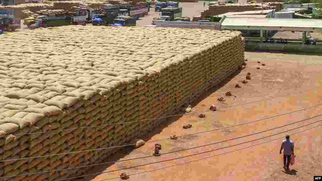 A man walks past sacks of grains at a market in Gedaref, eastern Sudan, on Feb. 22, 2024.