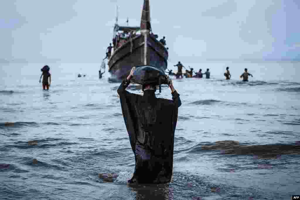 A Newly arrived Rohingya refugee walks to the beach after the local community decided to temporarily allow them to land for water and food in Ulee Madon, Aceh province, Indonesia, Nov. 16, 2023. 