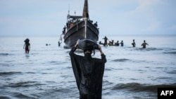 Seorang pengungsi Rohingya yang baru tiba berjalan ke pantai setelah masyarakat setempat memutuskan untuk mengizinkan mereka sementara mendarat untuk mendapatkan air dan makanan di Ulee Madon, Aceh, 16 November 2023.