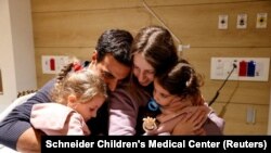 Yoni Asher bertemu kembali dengan istrinya Doron, dan kedua anaknya Aviv dan Raz di RS Schneider Children's Medical Center, di Petah Tikva Israel, setelah ketiganya dibebaskan, Sabtu, 25 November 2023. (Foto: Schneider Children's Medical Center via Reuters)